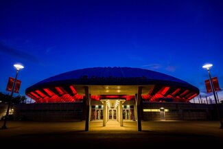 Exterior of State Farm Center at night with orange accent lights